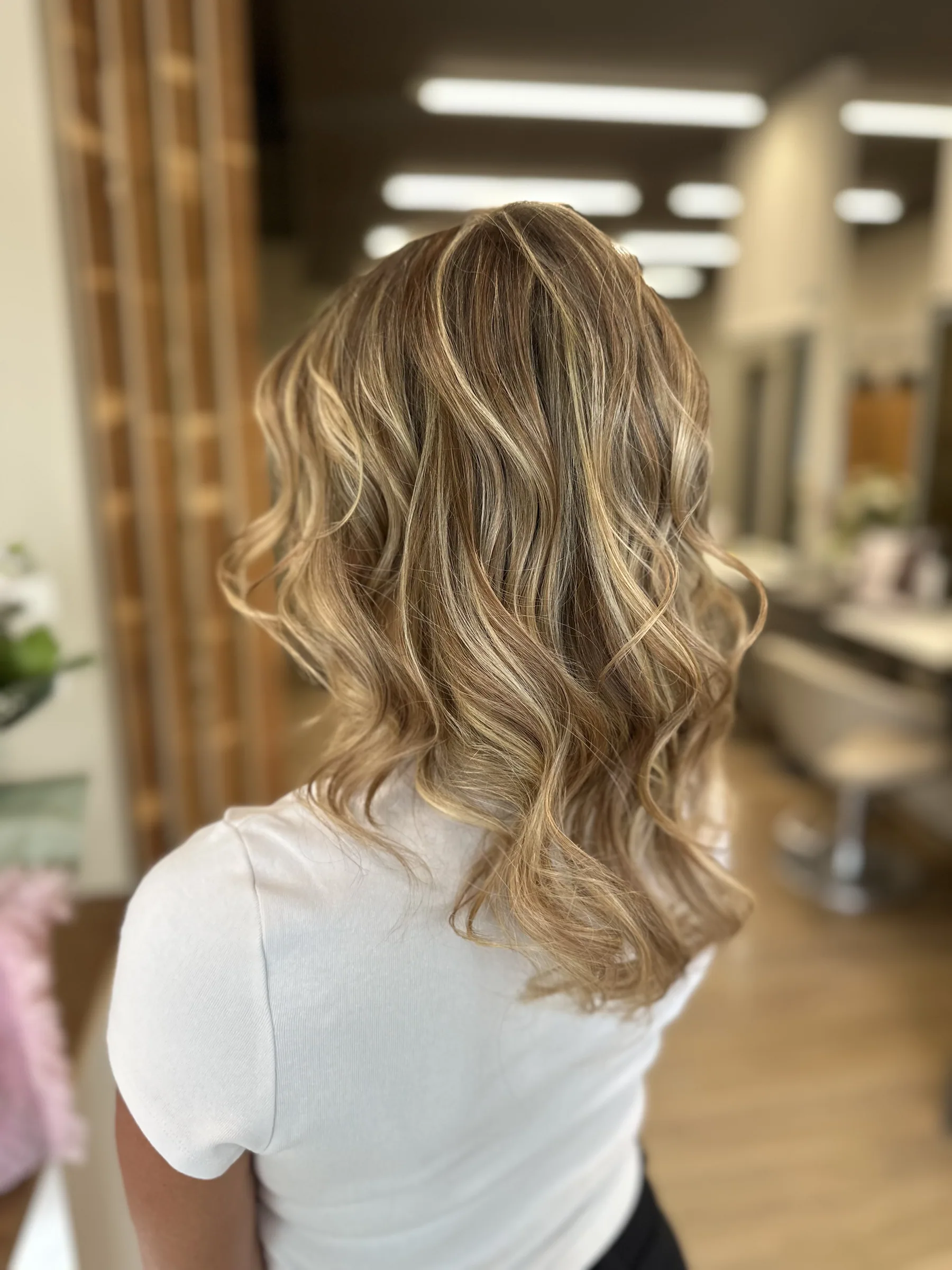 Capelli mossi biondo miele a media lunghezza, visti da dietro