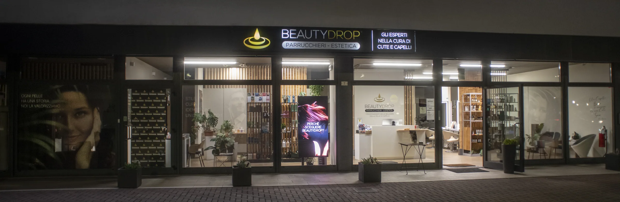 La vetrina del salone di sera, con l'insegna BEAUTYDROP illuminata